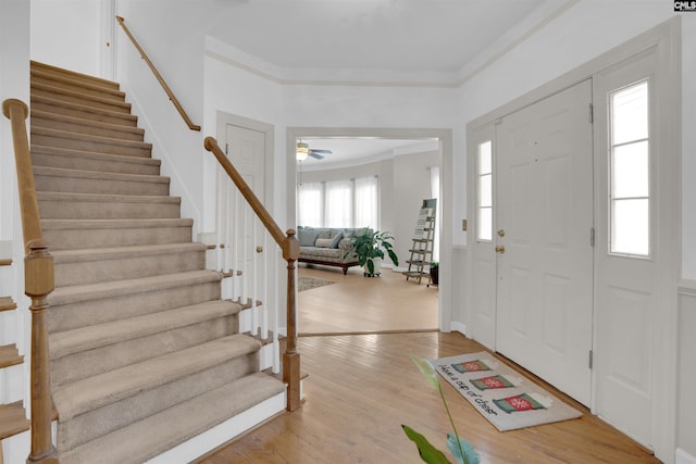 foyer entrance featuring ceiling fan, ornamental molding, and wood-type flooring