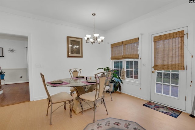 dining room featuring an inviting chandelier, hardwood / wood-style flooring, and ornamental molding