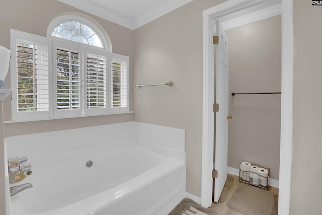 bathroom featuring hardwood / wood-style floors, crown molding, and a bath