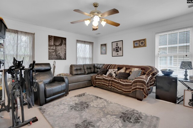 living room with crown molding, carpet floors, and ceiling fan