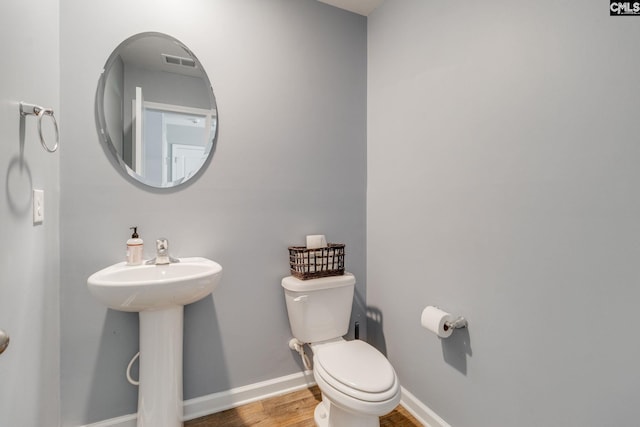 bathroom with hardwood / wood-style floors, sink, and toilet