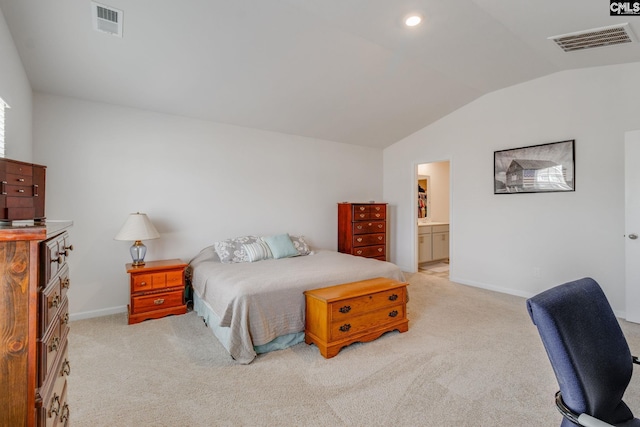 bedroom featuring lofted ceiling, connected bathroom, and light carpet