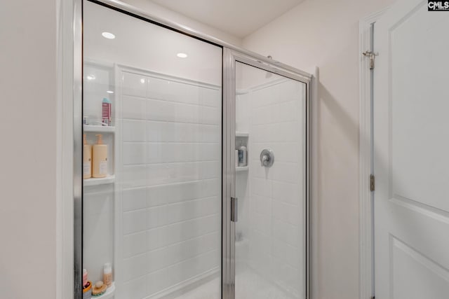 bathroom featuring a shower with shower door