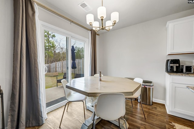 dining room featuring dark hardwood / wood-style floors and a chandelier