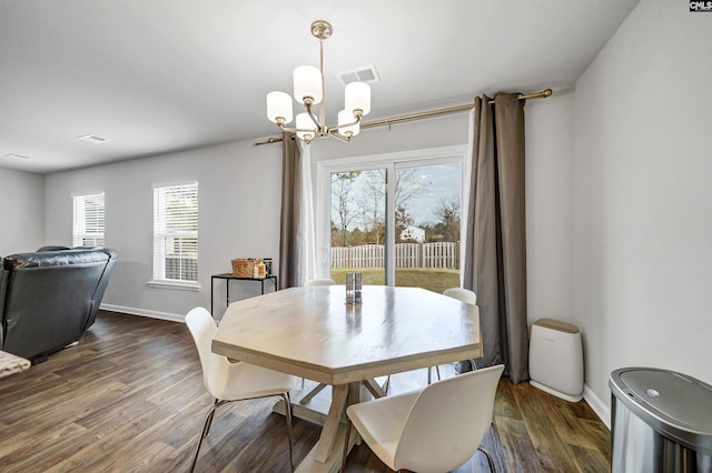 dining area with an inviting chandelier and dark wood-type flooring