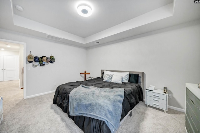 carpeted bedroom featuring a raised ceiling