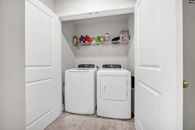 washroom featuring light tile patterned floors and washer and clothes dryer