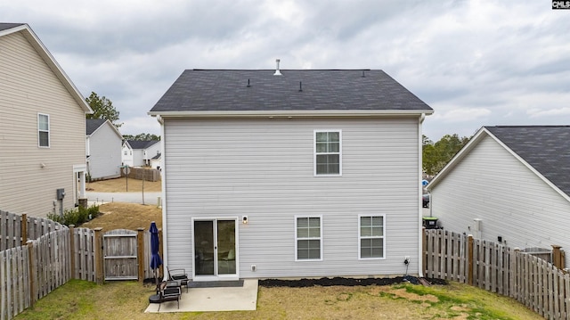 back of house with a patio area and a lawn