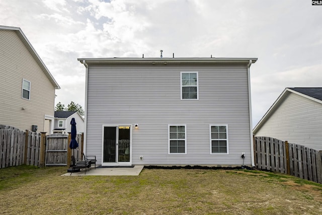 rear view of property with a yard and a patio area