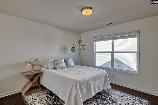 bedroom with dark hardwood / wood-style flooring