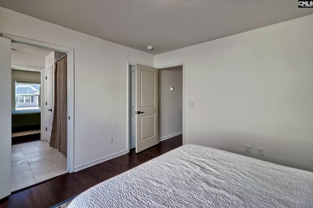 bedroom with dark hardwood / wood-style flooring