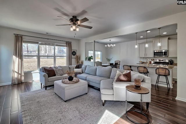 living room with ceiling fan with notable chandelier