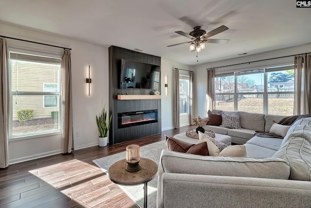 living room with ceiling fan, dark hardwood / wood-style floors, and a fireplace