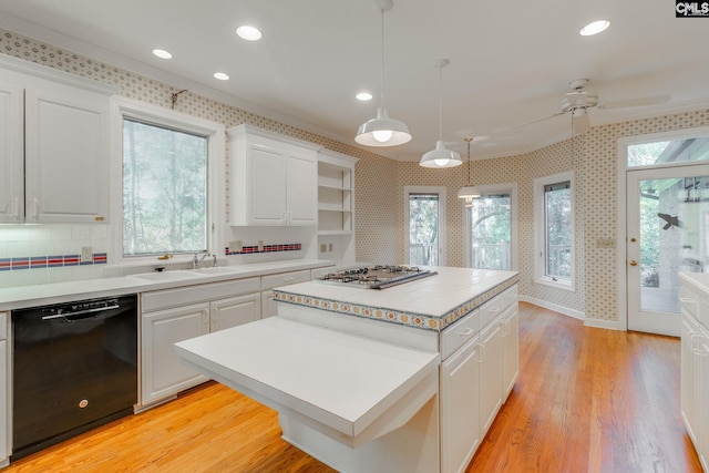 kitchen featuring a kitchen island, decorative light fixtures, dishwasher, white cabinets, and light wood-type flooring