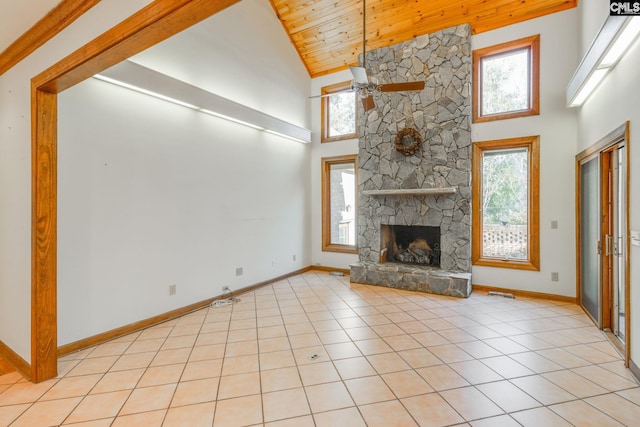 unfurnished living room with light tile patterned flooring, a stone fireplace, high vaulted ceiling, wooden ceiling, and ceiling fan