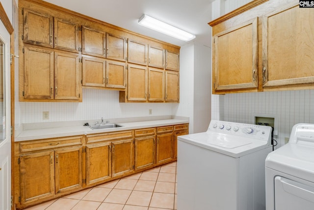 laundry area featuring cabinets, light tile patterned flooring, sink, and washer and clothes dryer