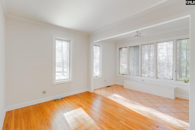 empty room with crown molding and light hardwood / wood-style floors