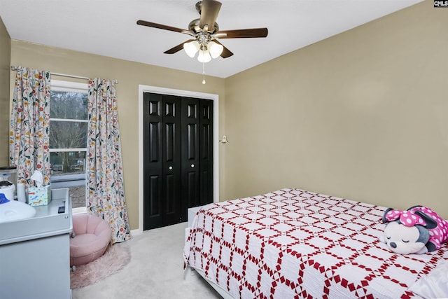 bedroom with light carpet, ceiling fan, and a closet