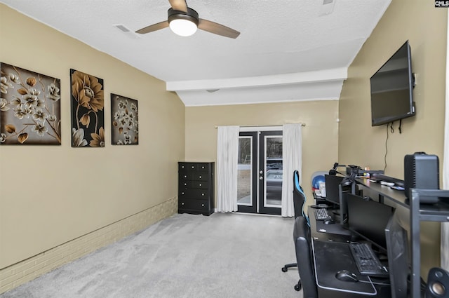 exercise area featuring light carpet, ceiling fan, and a textured ceiling