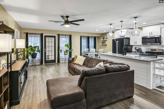 living room featuring wood-type flooring and ceiling fan