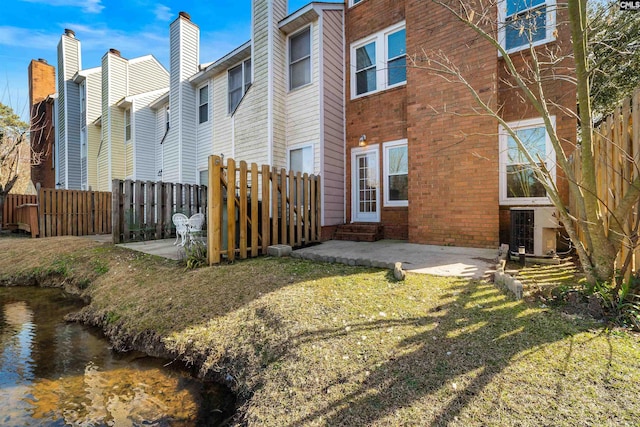 back of house with a yard and a patio