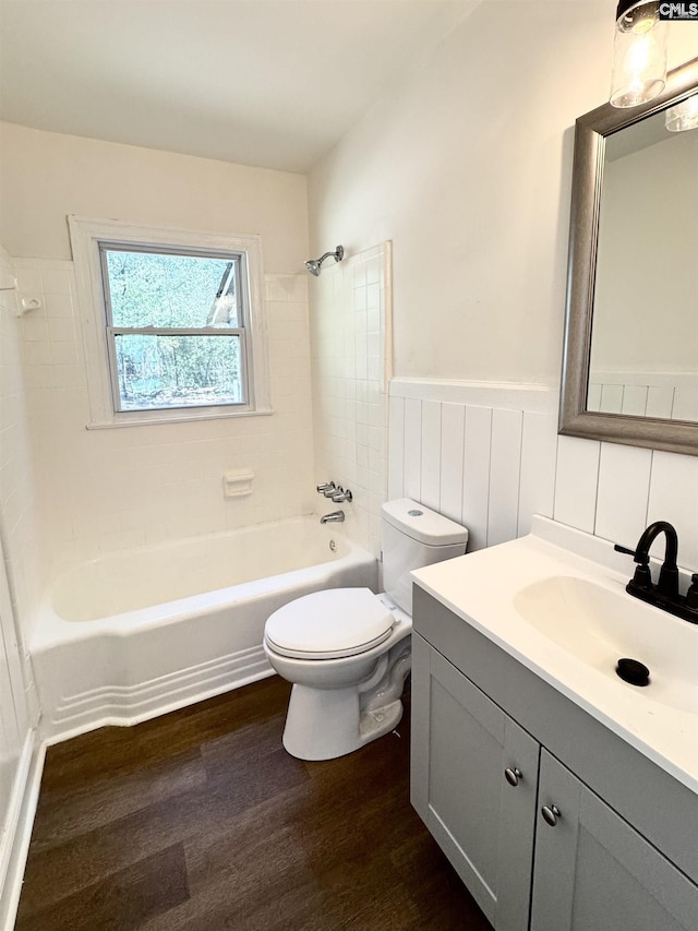 full bathroom featuring hardwood / wood-style flooring, vanity, toilet, and tiled shower / bath combo