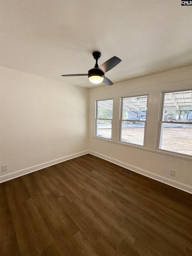 empty room with dark hardwood / wood-style floors and ceiling fan