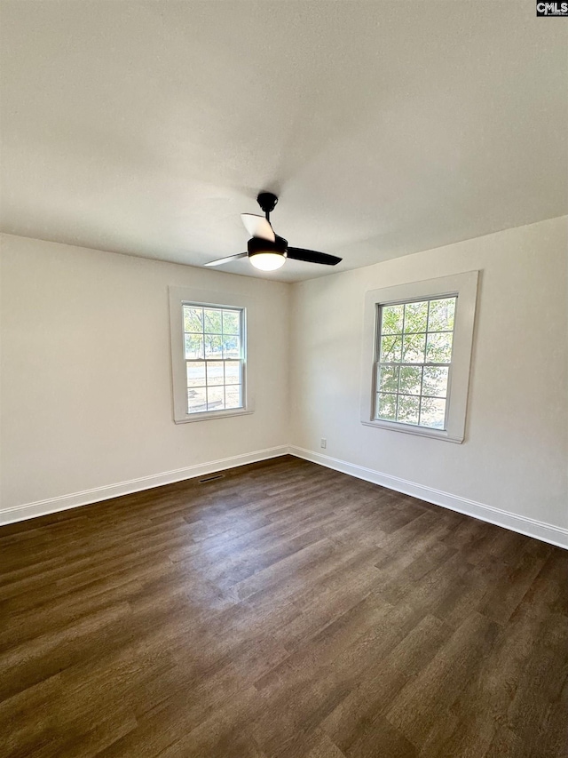 spare room with dark hardwood / wood-style floors and ceiling fan