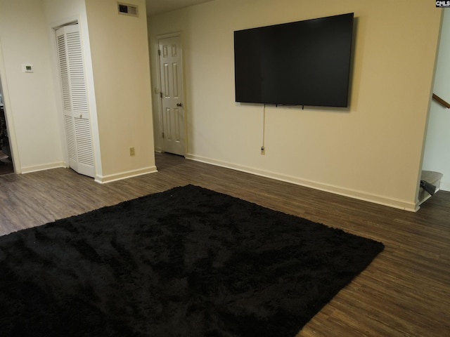 unfurnished bedroom featuring a closet and dark hardwood / wood-style floors