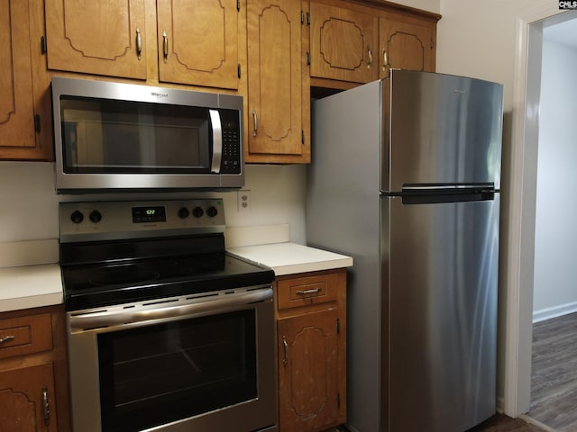 kitchen featuring dark hardwood / wood-style flooring and appliances with stainless steel finishes