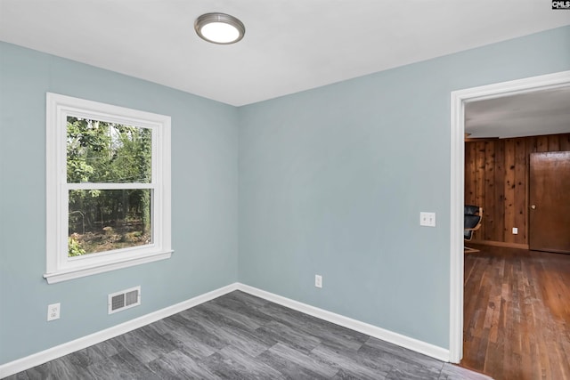 empty room with dark wood-type flooring and a healthy amount of sunlight