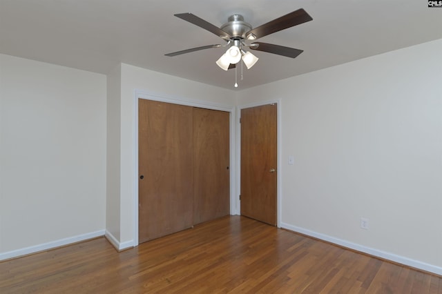 unfurnished bedroom featuring hardwood / wood-style flooring, ceiling fan, and a closet