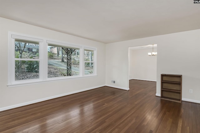 unfurnished room with dark hardwood / wood-style flooring and a chandelier