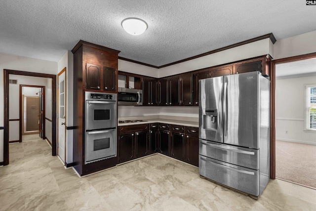 kitchen with dark brown cabinetry, crown molding, stainless steel appliances, and a textured ceiling