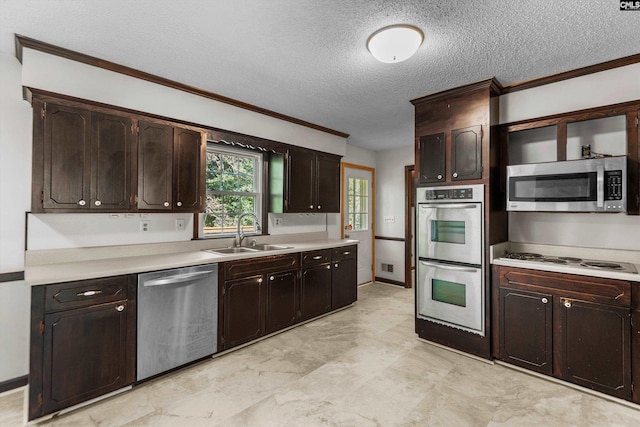 kitchen with sink, appliances with stainless steel finishes, dark brown cabinets, ornamental molding, and a textured ceiling