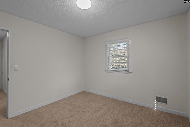 carpeted spare room with a textured ceiling