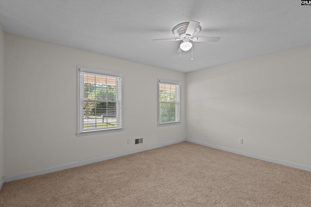 unfurnished room with ceiling fan, light colored carpet, and a textured ceiling