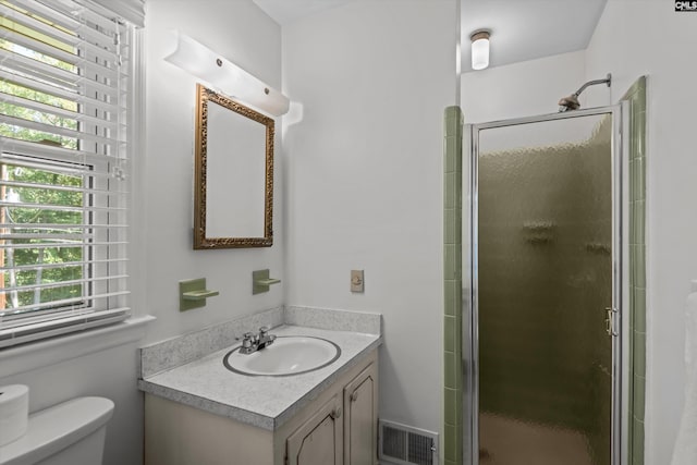 bathroom featuring vanity, toilet, and walk in shower