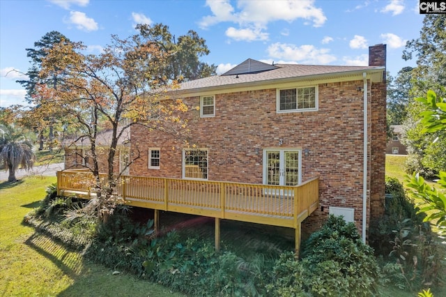 rear view of property with a wooden deck and a yard