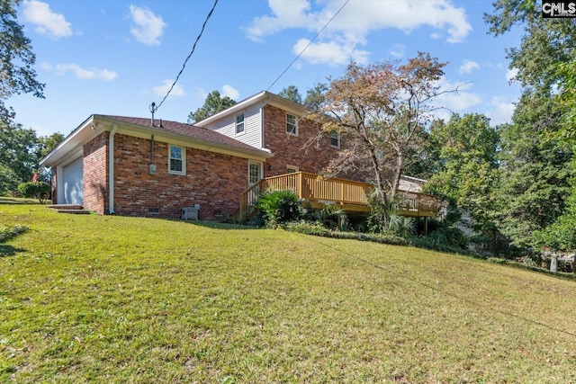 exterior space with a garage, a wooden deck, and a lawn