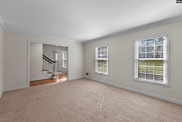 unfurnished room featuring crown molding, carpet floors, and a textured ceiling