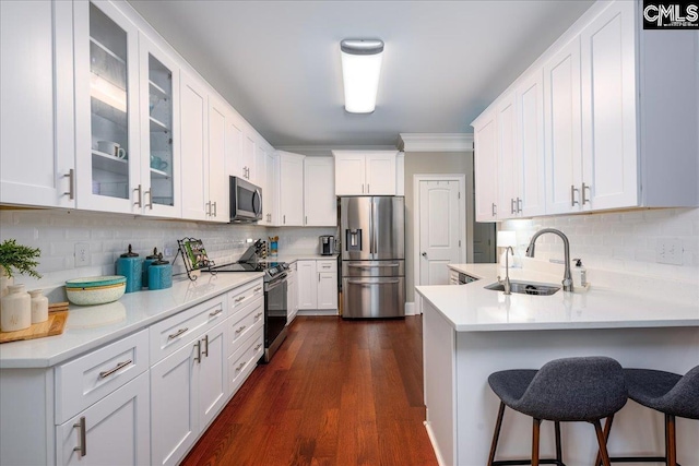 kitchen featuring appliances with stainless steel finishes, sink, white cabinets, and backsplash