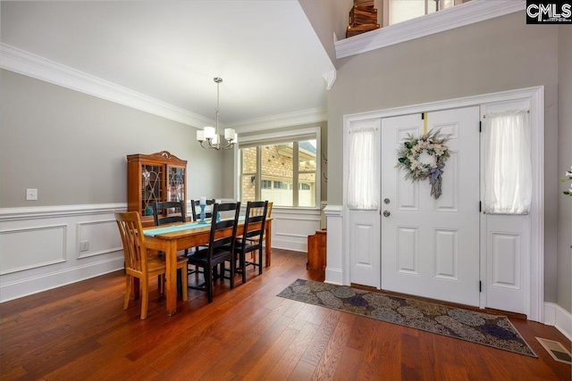 foyer entrance featuring crown molding, dark hardwood / wood-style flooring, and a chandelier