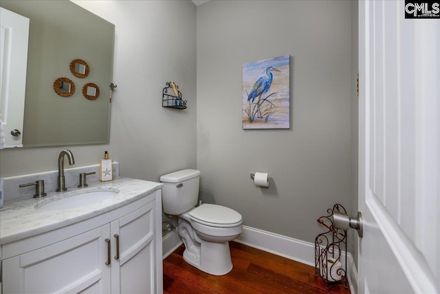 bathroom featuring vanity, hardwood / wood-style flooring, and toilet