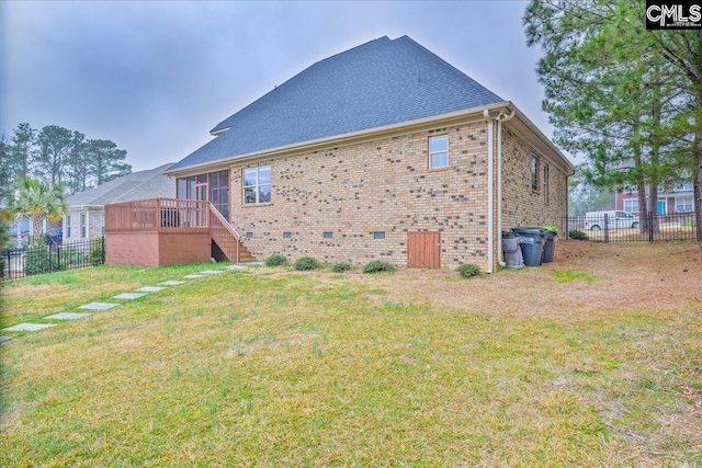 rear view of house featuring a deck and a lawn