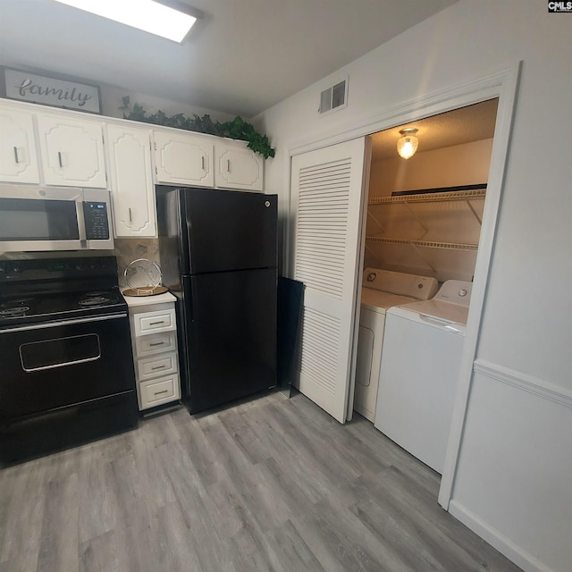 kitchen featuring black appliances, washer and dryer, light hardwood / wood-style floors, decorative backsplash, and white cabinets