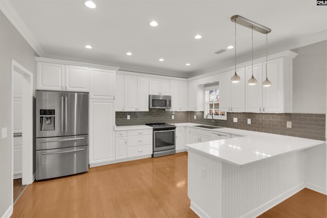 kitchen featuring white cabinetry, appliances with stainless steel finishes, kitchen peninsula, and pendant lighting