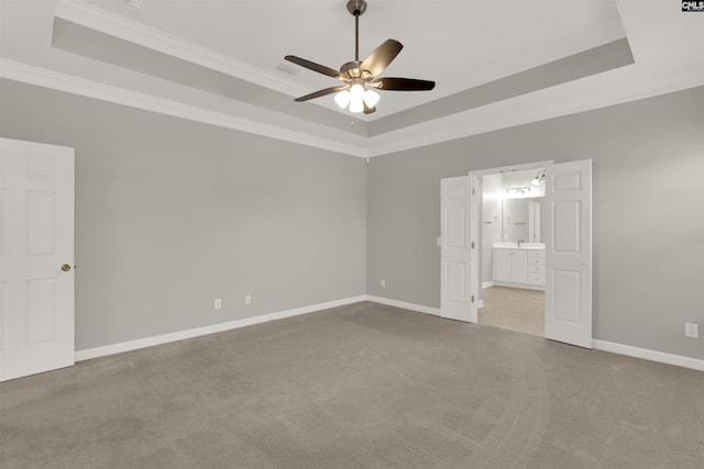 unfurnished bedroom featuring ornamental molding, light colored carpet, and a raised ceiling