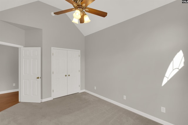 unfurnished bedroom with carpet floors, high vaulted ceiling, a closet, and ceiling fan