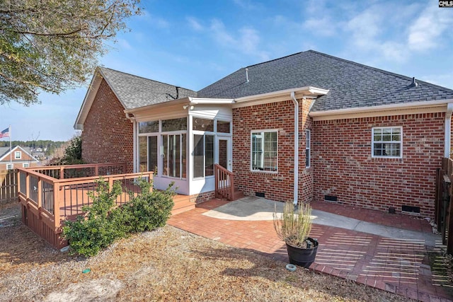 rear view of property with a sunroom, a deck, and a patio